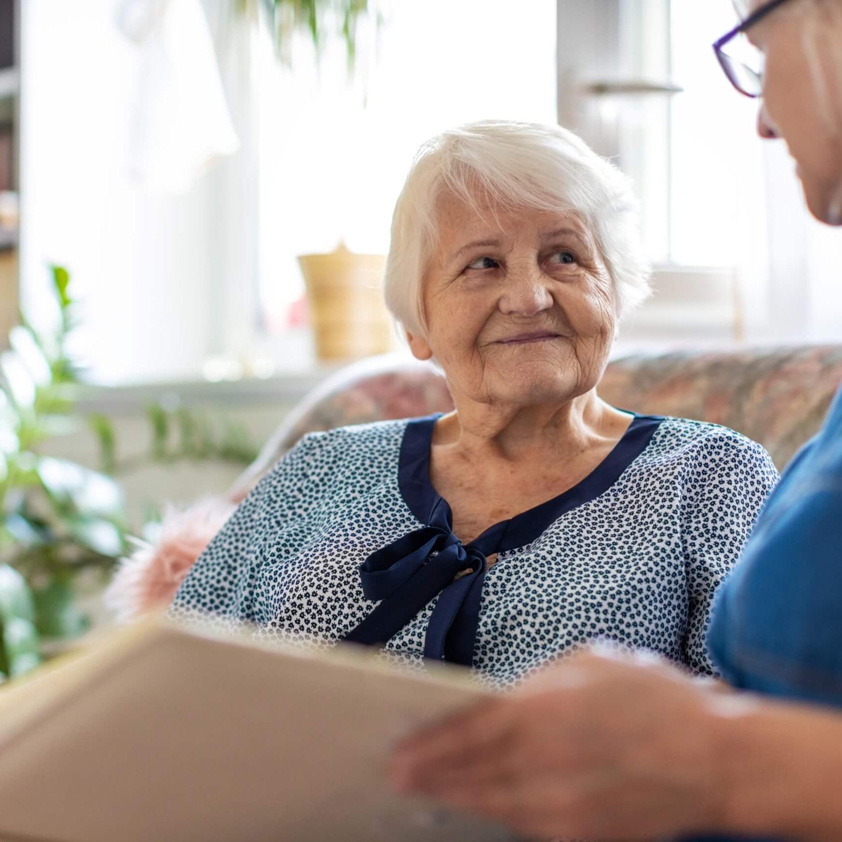 Elderly woman reading with caregiver