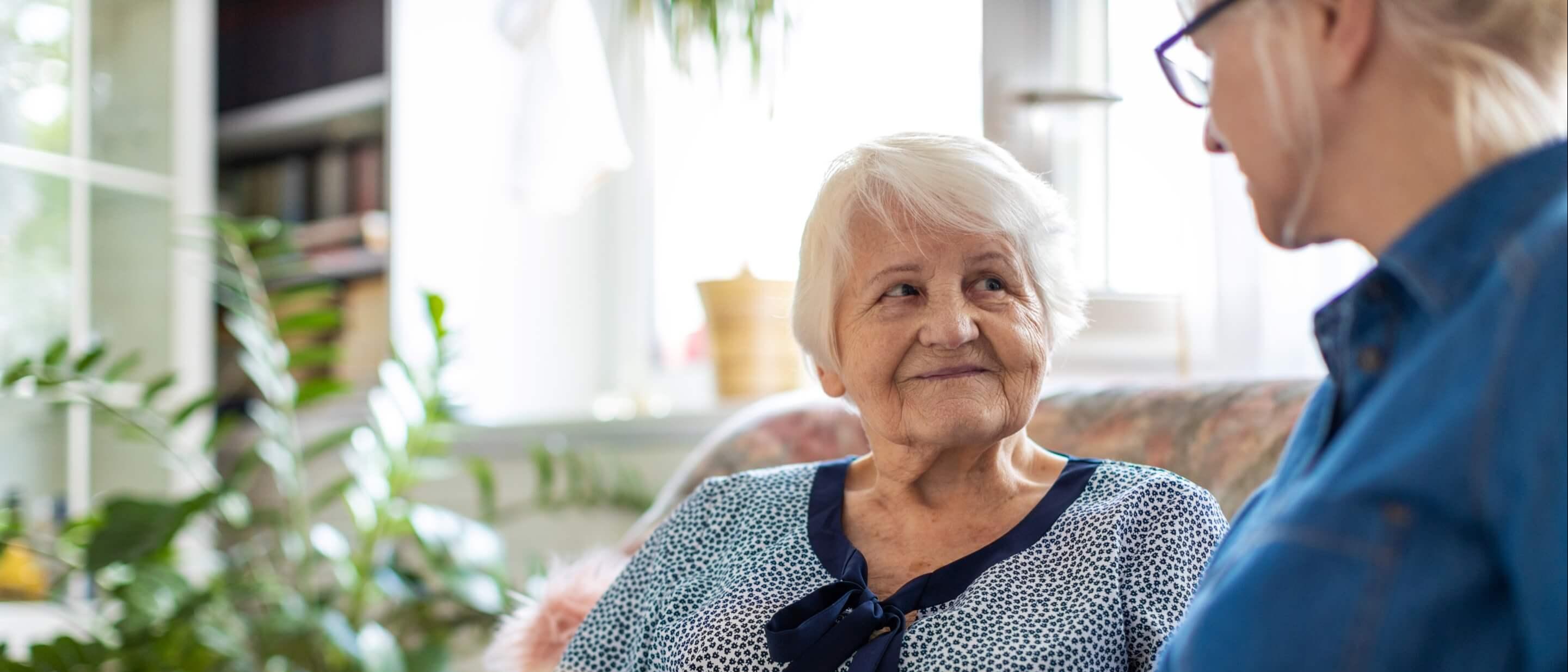 Elderly woman reading with caregiver