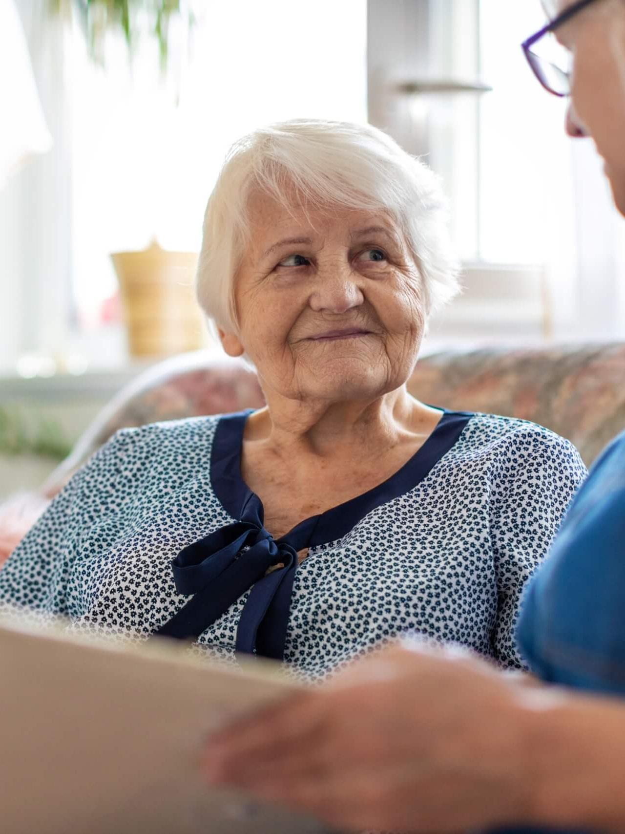 Elderly woman reading with caregiver