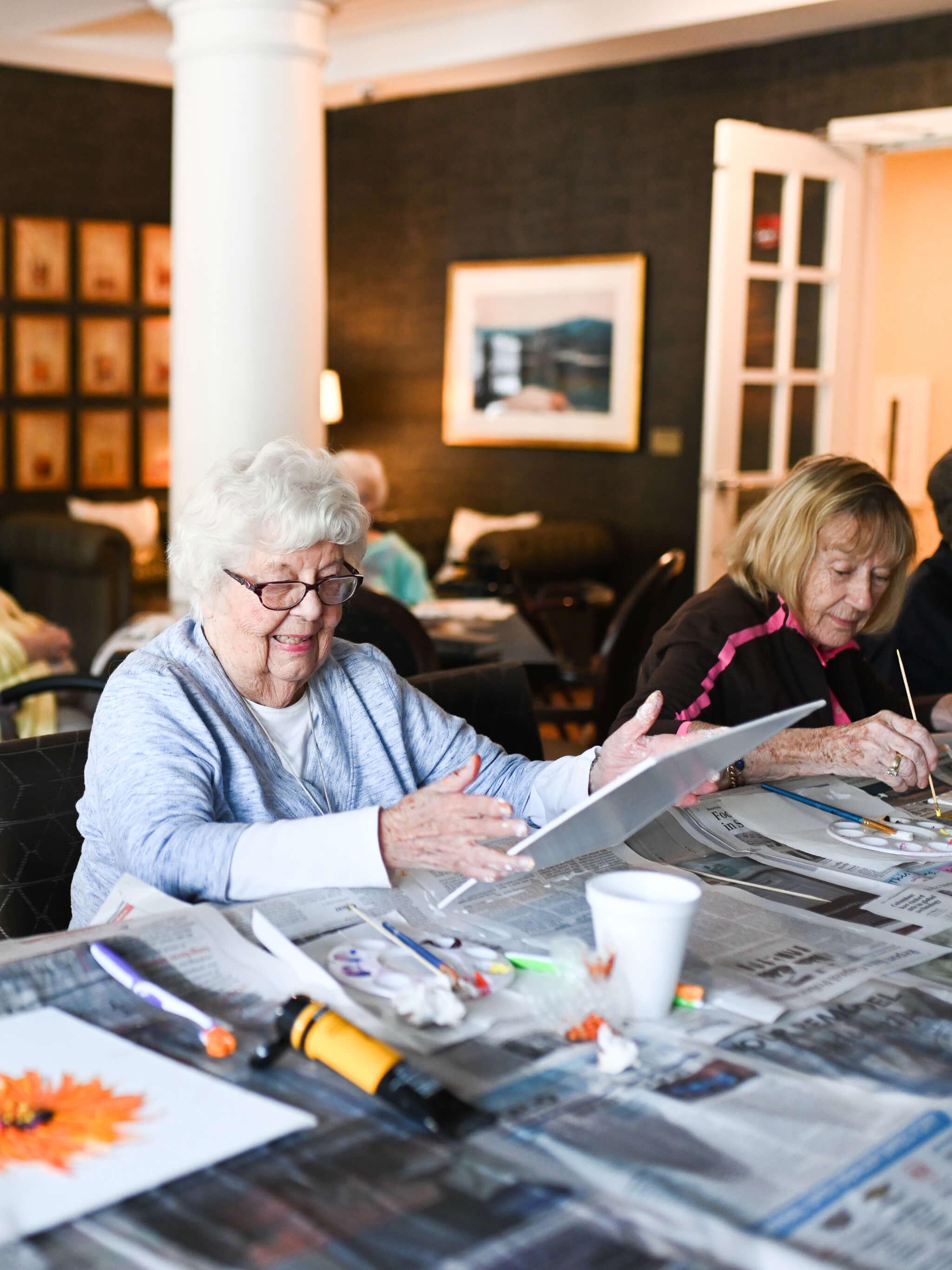 resident looking at a piece of artwork she painted