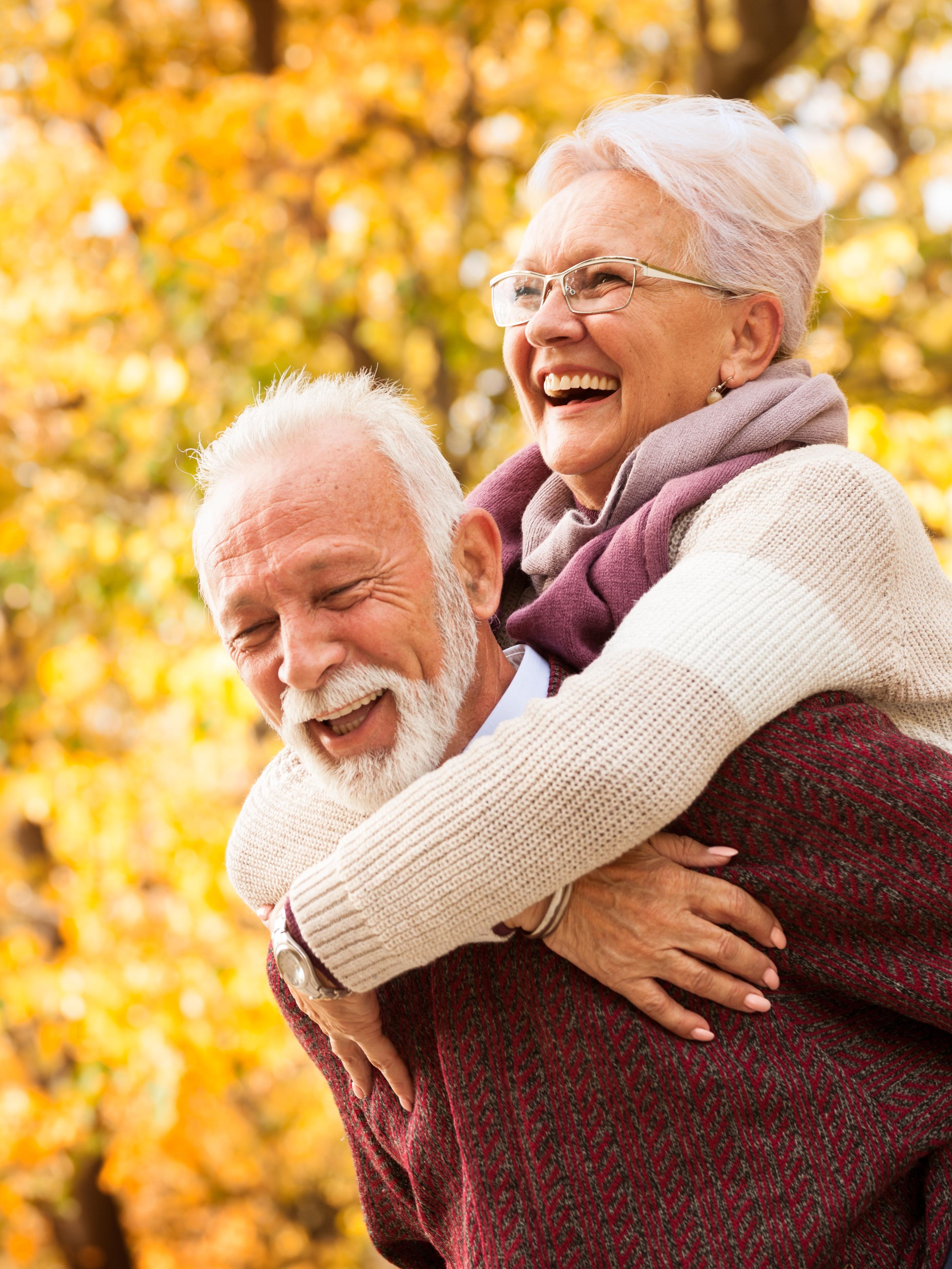 smiling elderly couple, a woman carried by a man