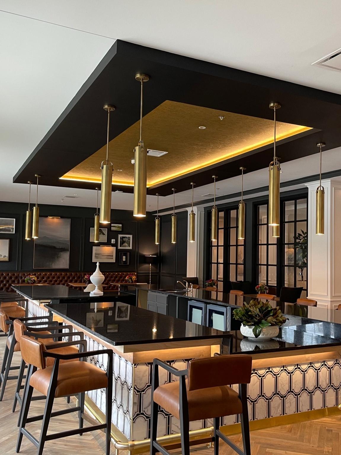 Modern bar setting with stylish pendant lighting, leather bar stools, and a dark wood finish